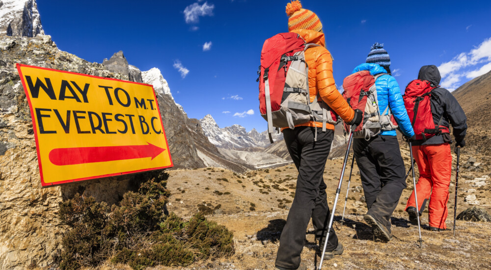 Group of three trekkers passing signpost "Way to Mount Everest Base Camp" - Mount Everest (Sagarmatha) National Park. This is the highest national park in the world, with the entire park located above 3,000 m ( 9,700 ft). This park includes three peaks higher than 8,000 m, including Mt Everest. Therefore, most of the park area is very rugged and steep, with its terrain cut by deep rivers and glaciers. Unlike other parks in the plain areas, this park can be divided into four climate zones because of the rising altitude.http://bhphoto.pl/IS/nepal_380.jpg
